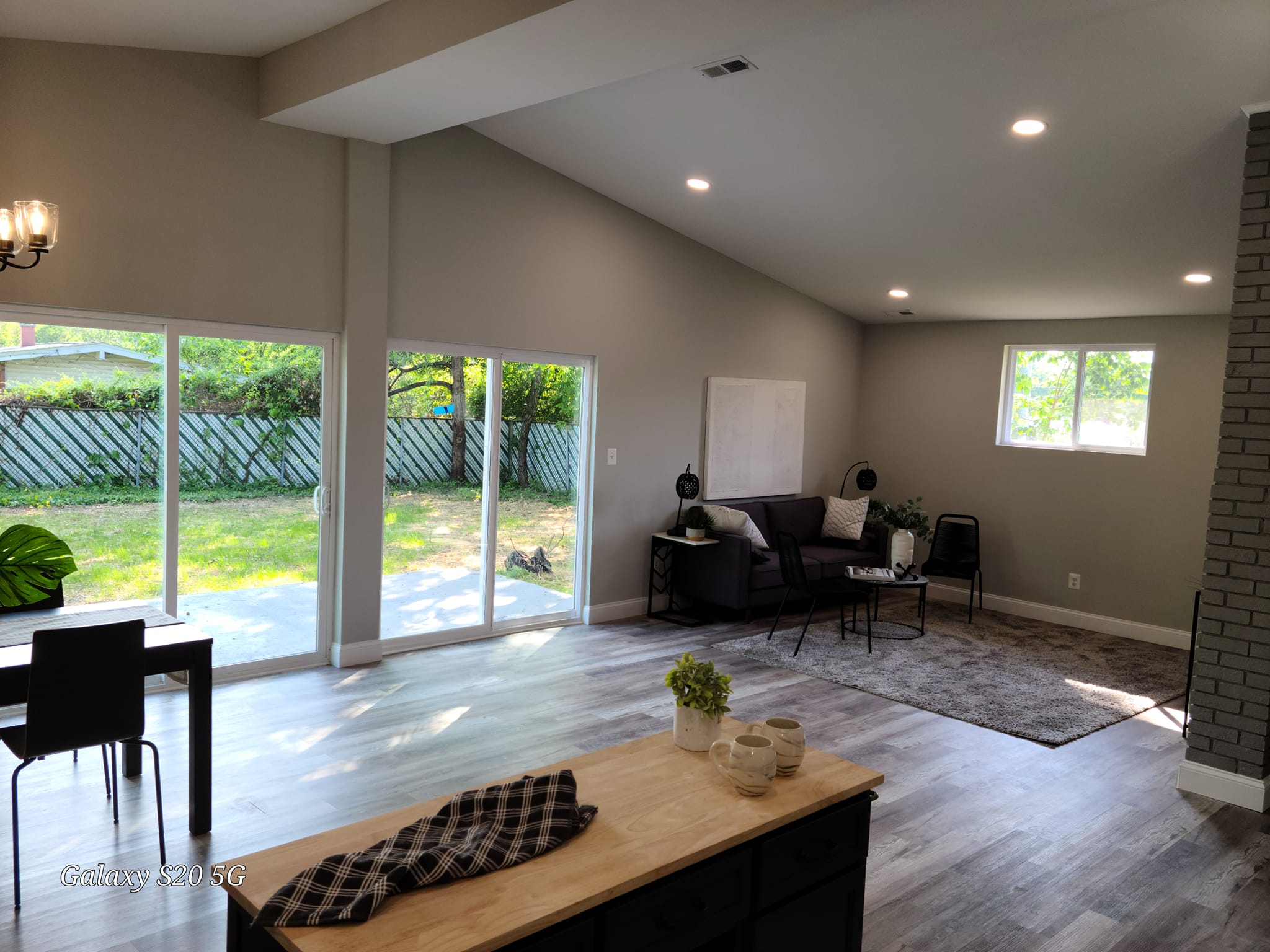 Bright living area with two white sliding glass patio doors to the backyard