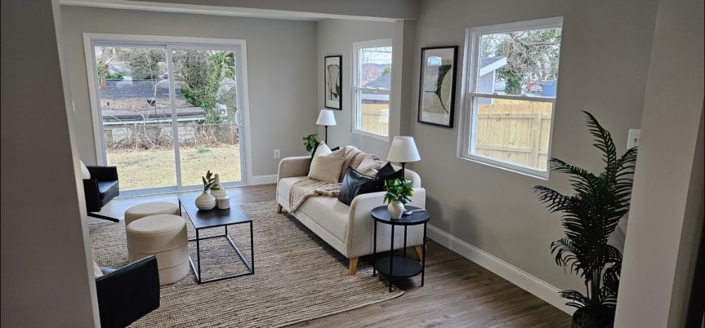 Living room with white-framed sliding glass patio door and two white vertical windows on gray walls